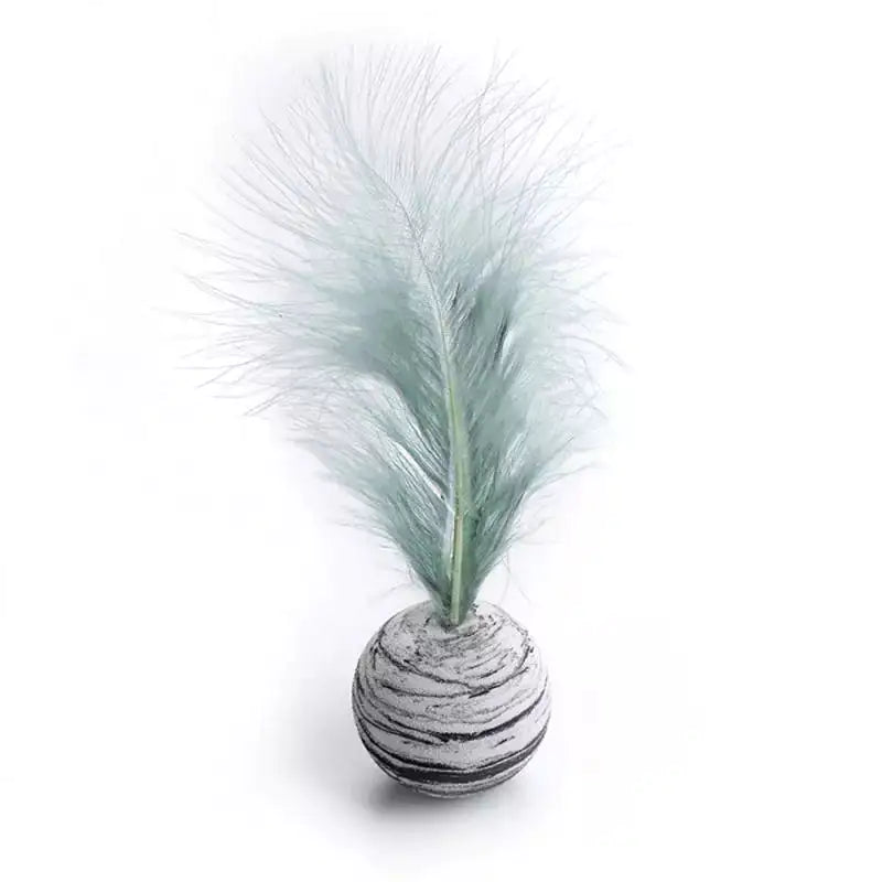 Decorative feathered ball with a textured surface on a white background