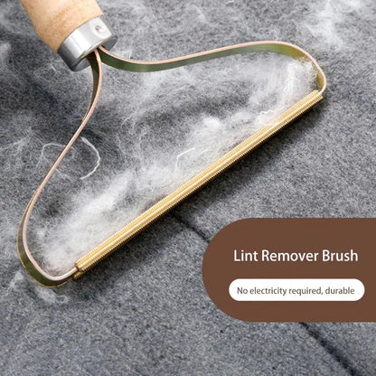Lint remover brush with wooden handle and metal head on a textured gray background