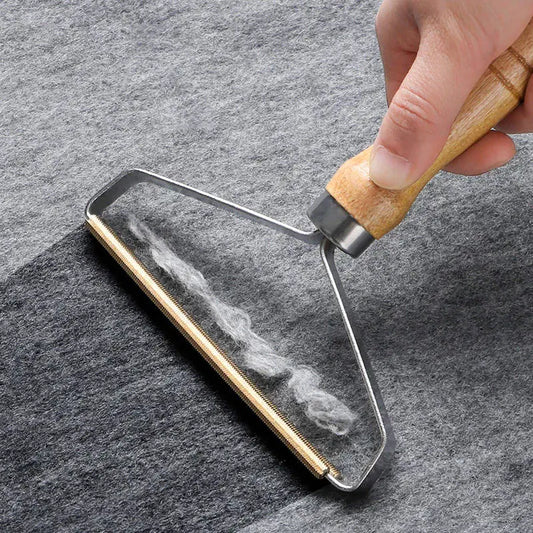 Hand using a glass cleaning tool on a smartphone screen against a gray background