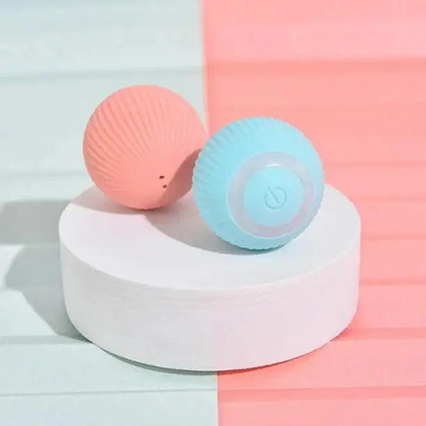 Two colorful massage balls on a white and pink geometric surface