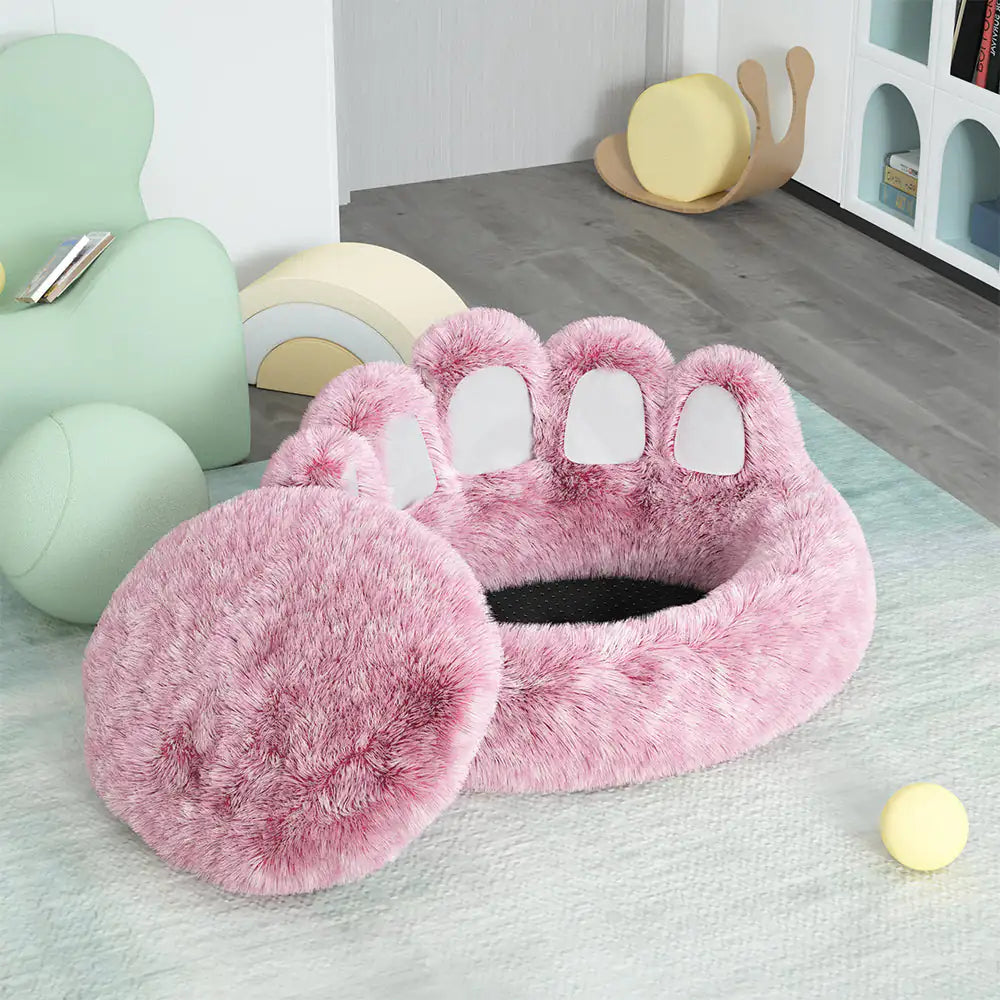Pink paw-shaped pet bed on a light green rug with colorful chairs in the background