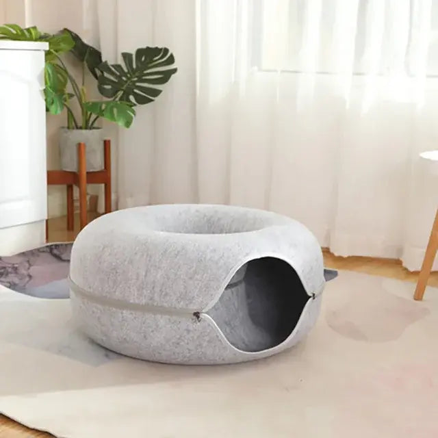 Gray pet bed in a room with curtains and plants