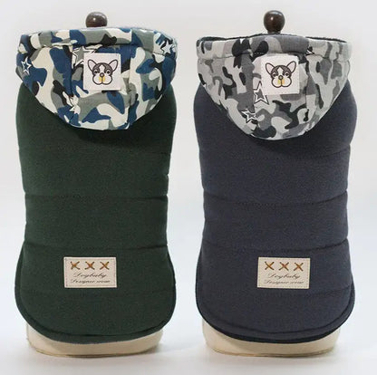 Two dog coats with camouflage hoods and brand labels on a white background