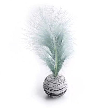 Decorative feathered ball with a textured surface on a white background