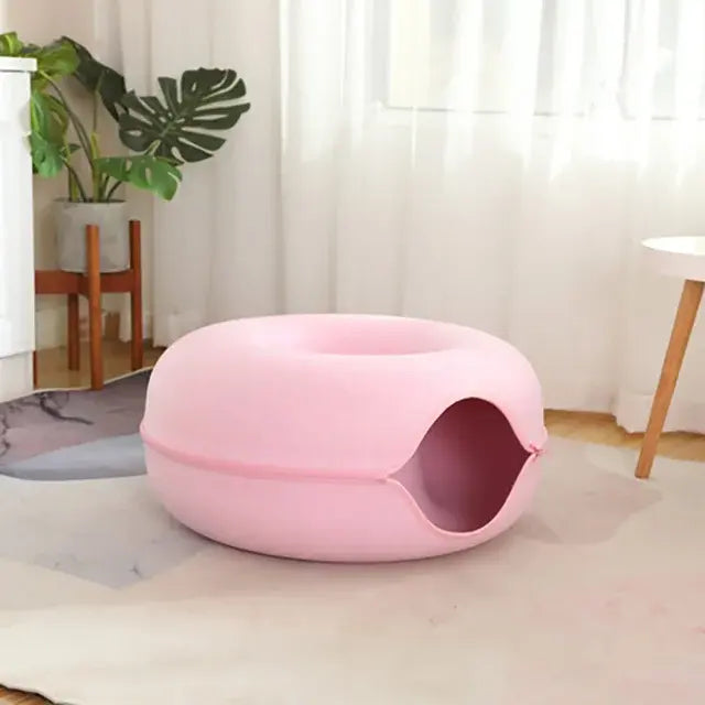 Pink pet bed in a room with a plant and table