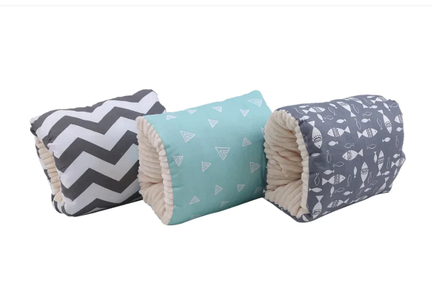 Three cylindrical pillows with different patterns on a white background