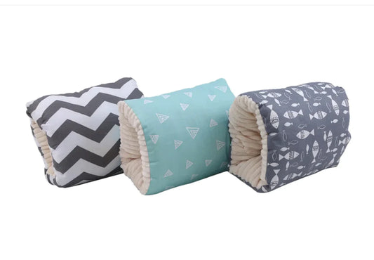 Three cylindrical pillows with different patterns on a white background