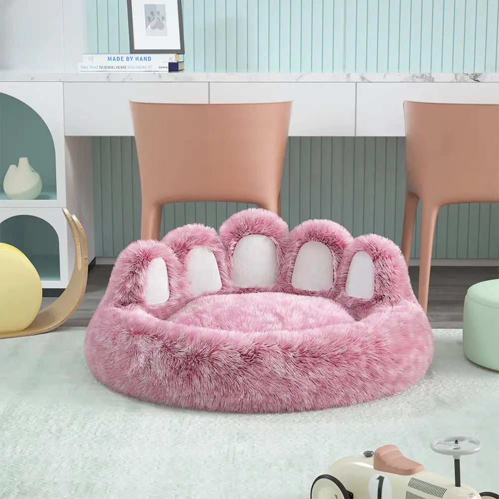 Pink paw-shaped pet bed in a room with chairs and a desk.