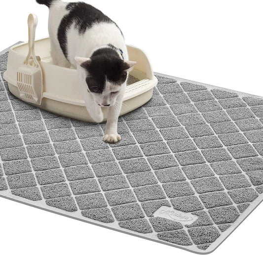 Cat using a litter box on a gray mat with a white background